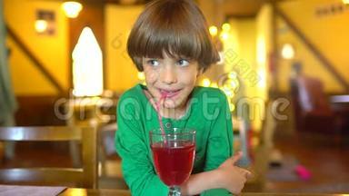 孩子喝<strong>果汁</strong>。 快乐的小可爱男孩通过吸管和微笑喝着浆<strong>果汁</strong>冰沙的肖像
